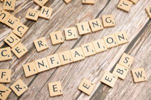 Scrabble game pieces spelling the words rising inflation.