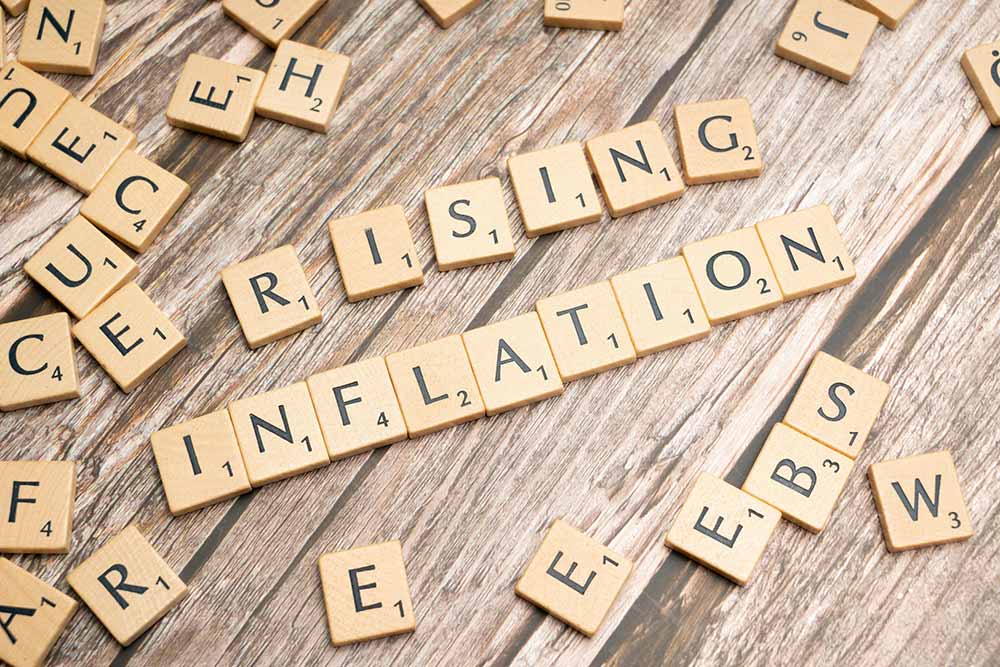 Scrabble game pieces spelling the words rising inflation.