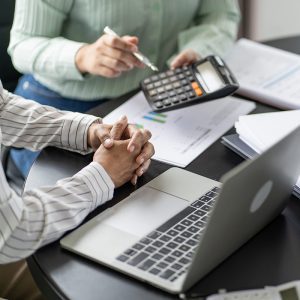 Close up of a woman showing a man figures on a calculator.