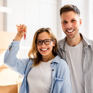 Happy couple showing keys to new home.